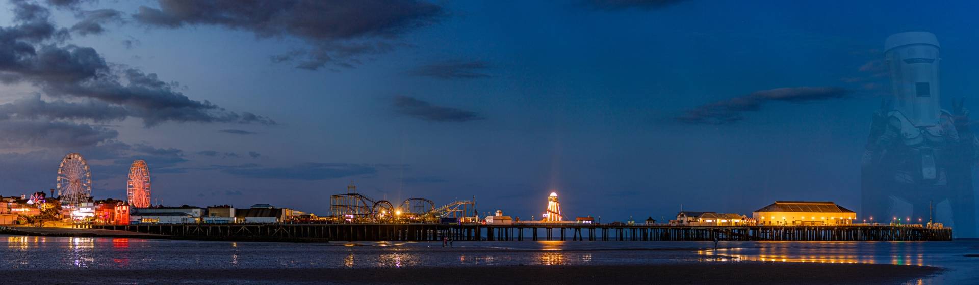 Wide view of the Clacton-on-Sea coastline, beach, and pier on a bright summer day